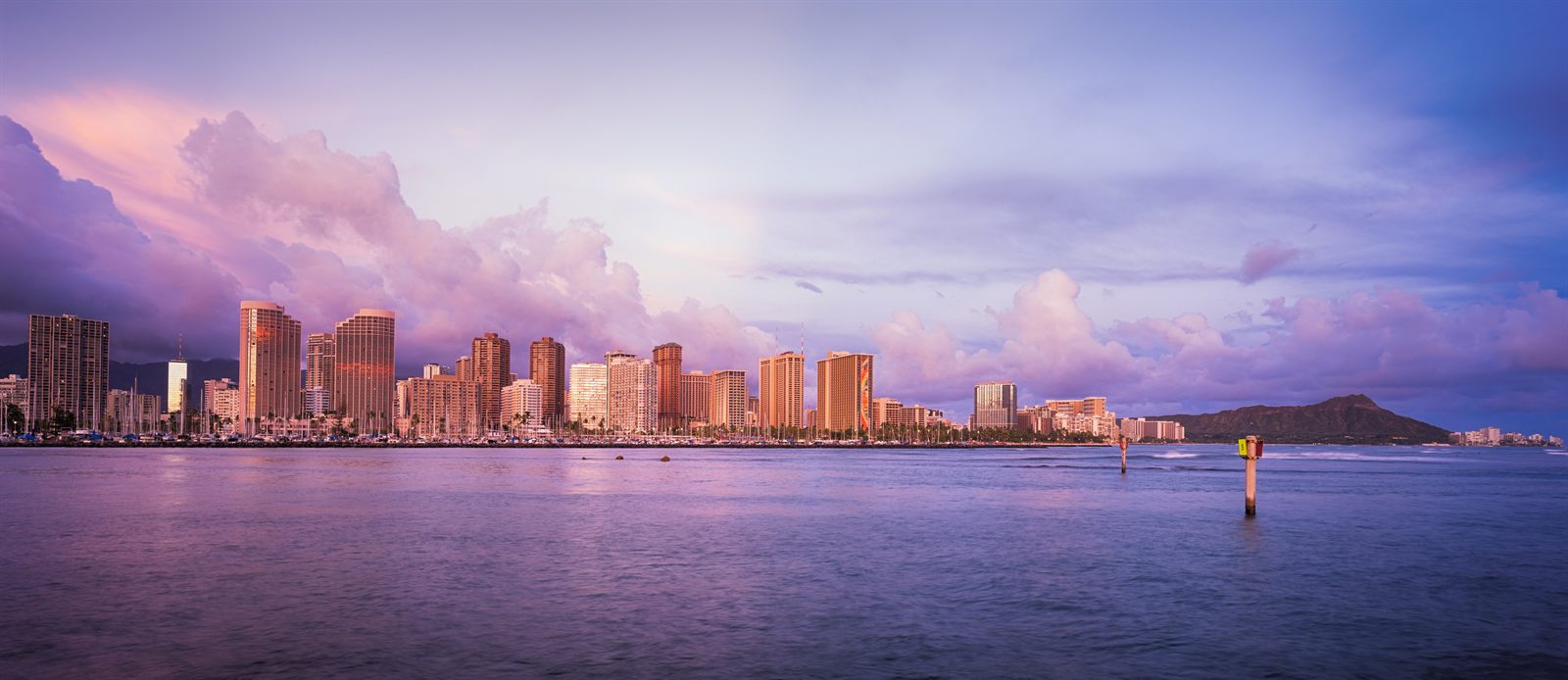Honolulu skyline at dusk across the water, the city between the Honolulu cruise port and the airport