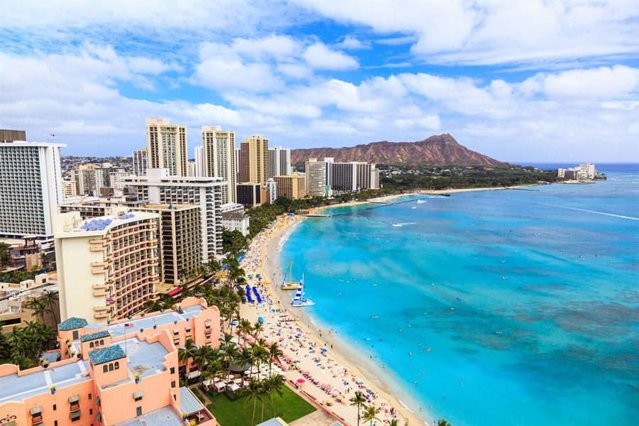 Swimmers and hotel towers along the curve of Waikiki Beach